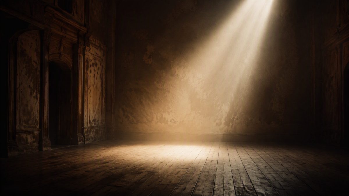 Leere Bühne eines alten Theaters: ein einziger warmer Lichtstrahl fällt durch leichten Dunst auf den Holzboden